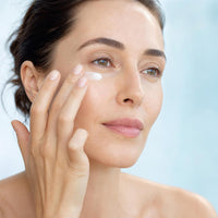 Mujer aplicándose la crema Koriderm+ en el contorno de ojos